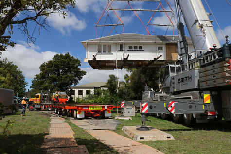 The top half of the building is raised then lowered onto the transporter. Photo: Star Media