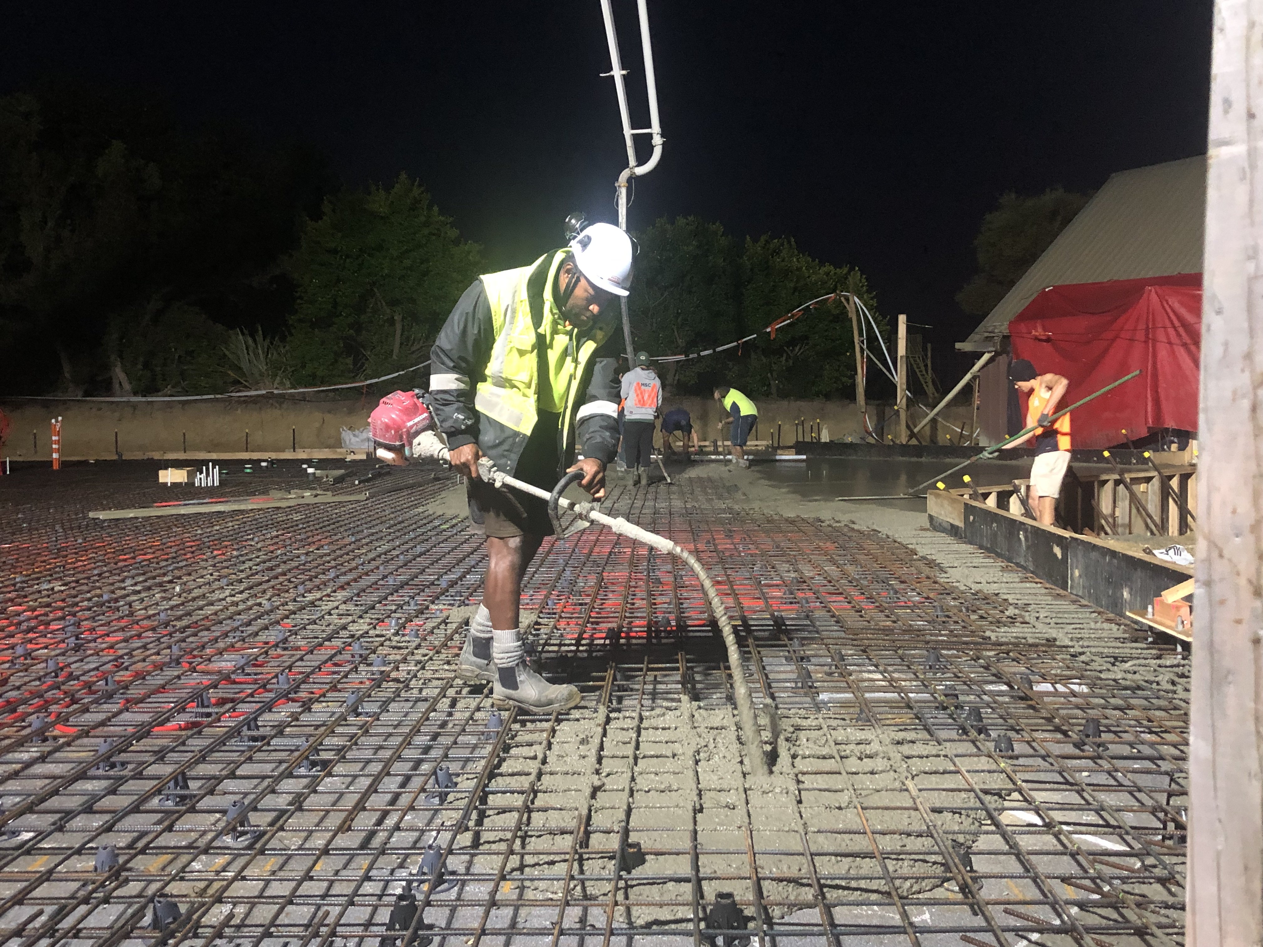 Anderson Construction contractor Filimoni Tagicakibau pours concrete over the mauri stone at the...