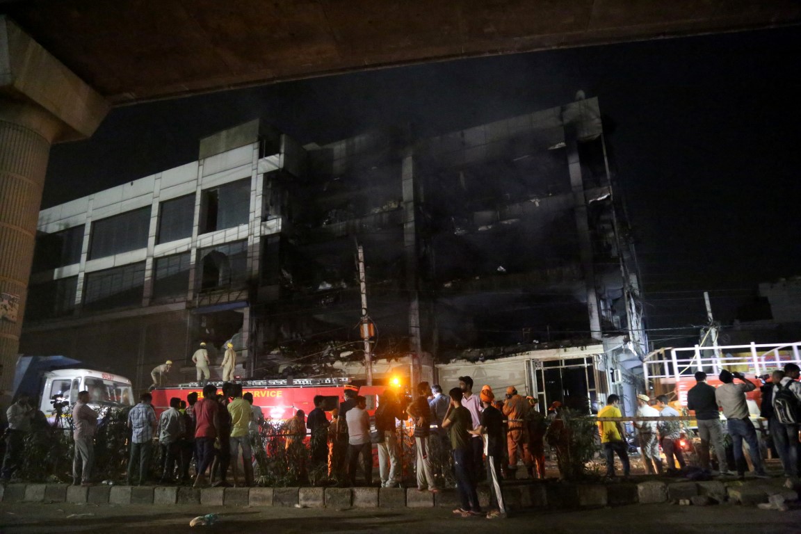 Rescue members and onlookers watch as as firefighters tackle the blaze. Photo: Reuters