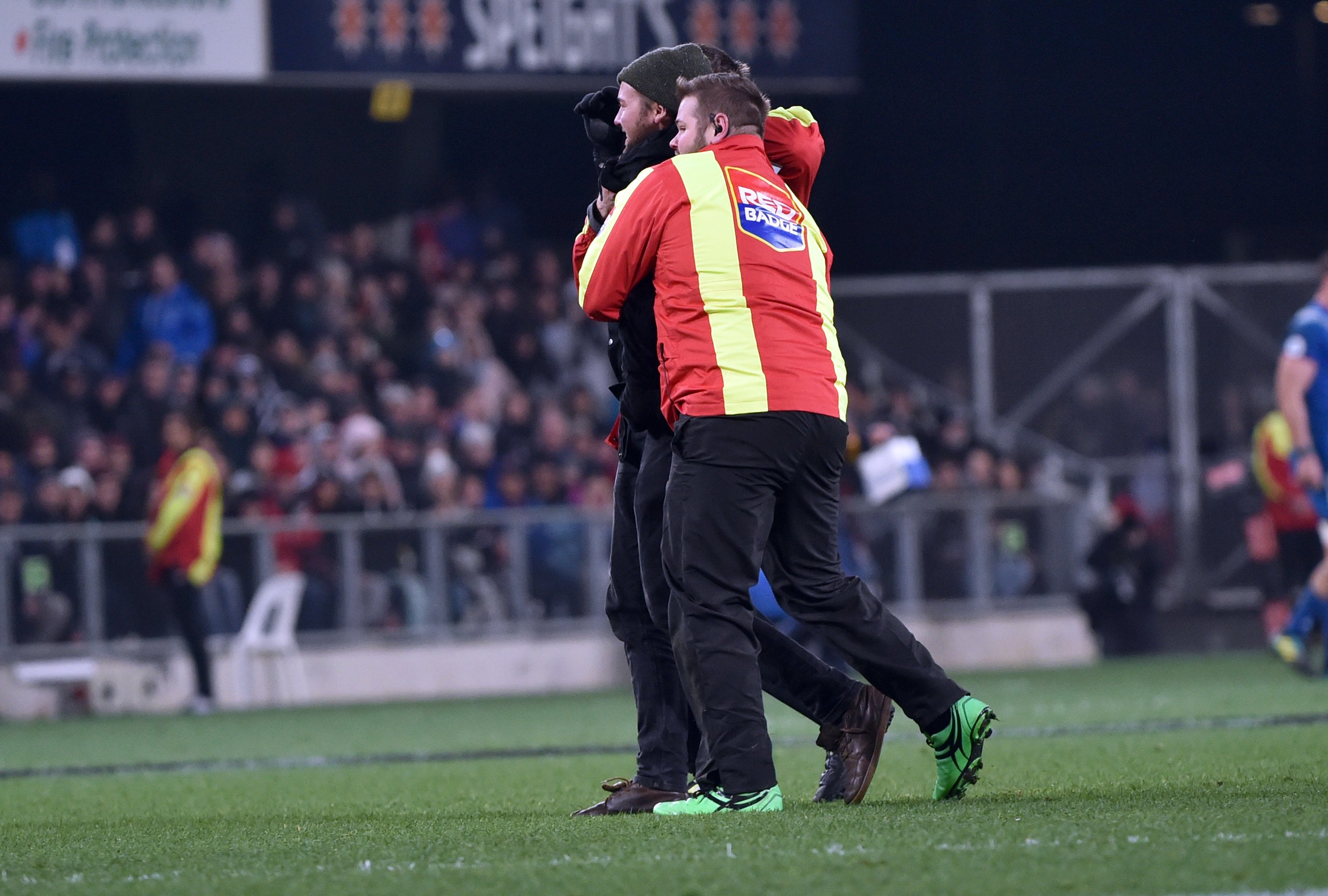A Red Badge security guard walks a pitch invader off the field at an All Blacks test at Forsyth...