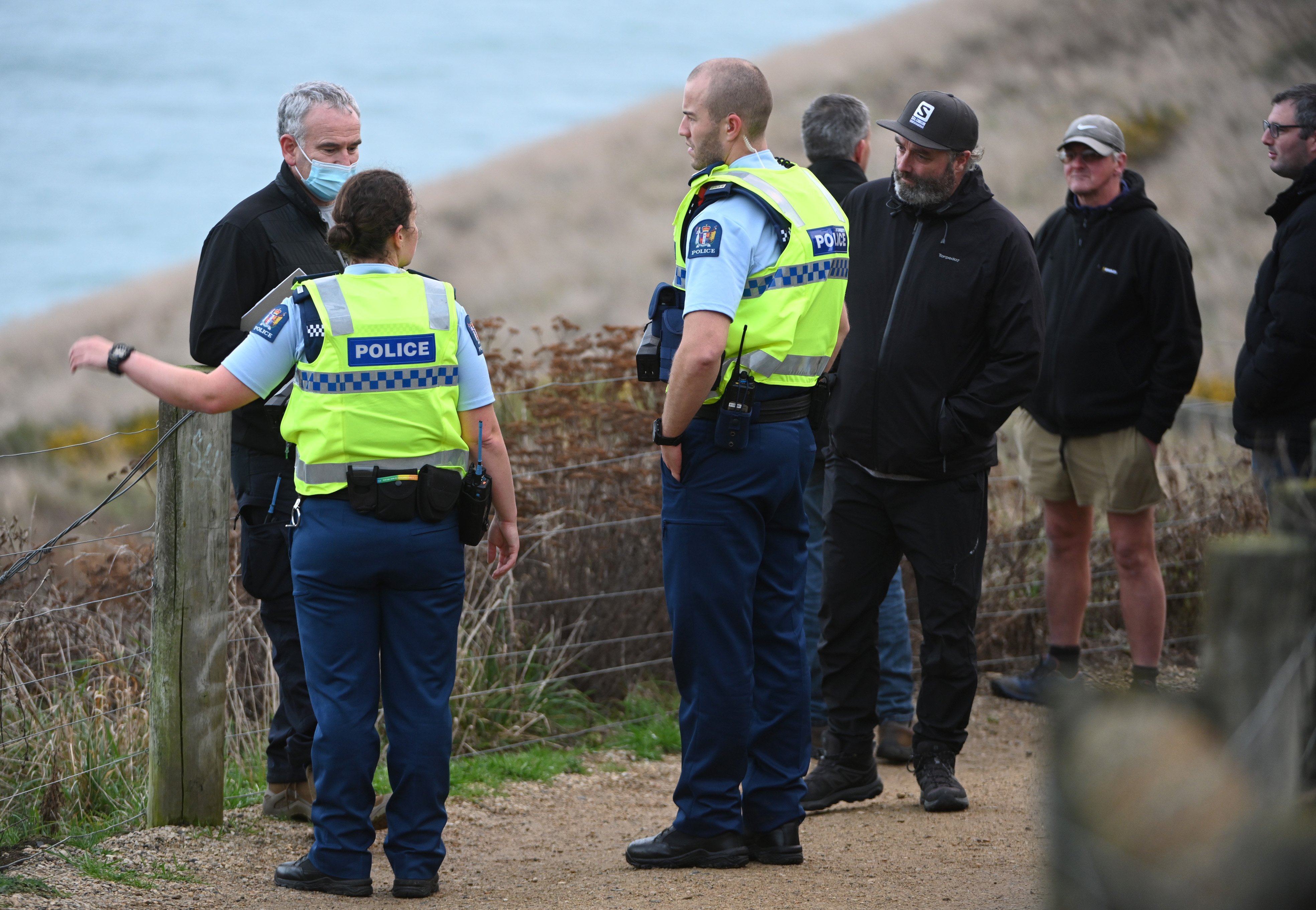 Police talk to personnel from Search and Rescue at Tunnel Beach yesterday. PHOTO: LINDA ROBERTSON