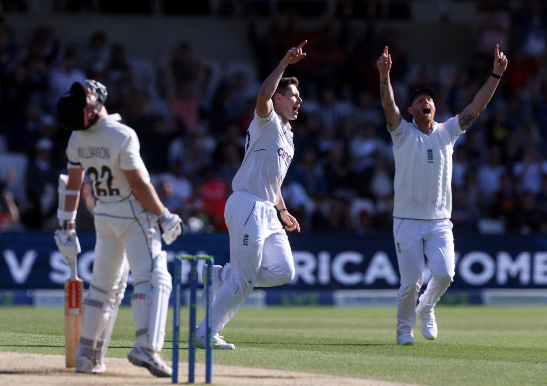 England's Matthew Potts (C) celebrates alongside teammate Ben Stokes after taking the wicket of...