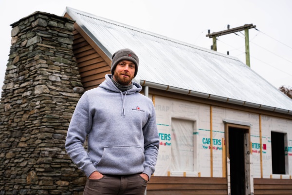 Builder John Hudson by the formerly-dilapidated Hicks Cottage he and his team are restoring....