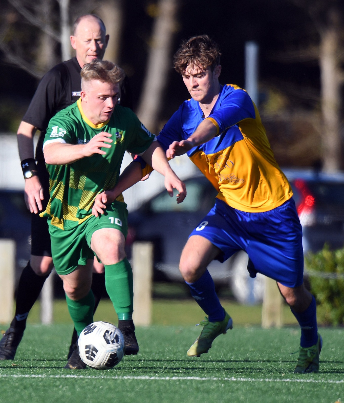 Green Island’s Cam Anderson looks to dribble past Otago University’s Hugo Davidson as referee...