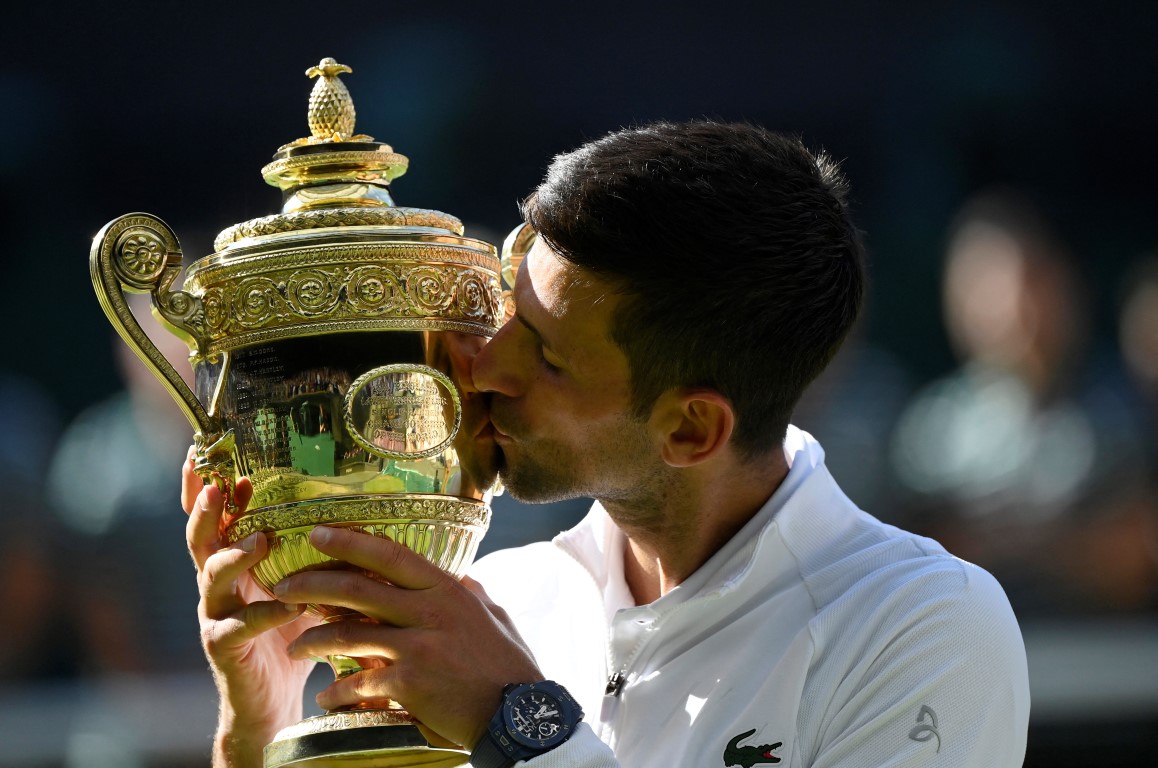 Novak Djokovic celebrates with the trophy after his Wimbledon final victory over Nick Kyrgios....