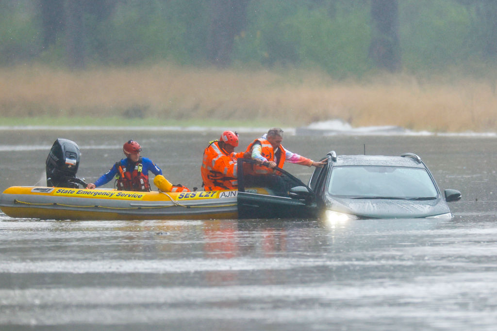 A man is rescued from a vehicle stuck in floodwaters in Windsor, northwest of Sydney. Photo: Getty