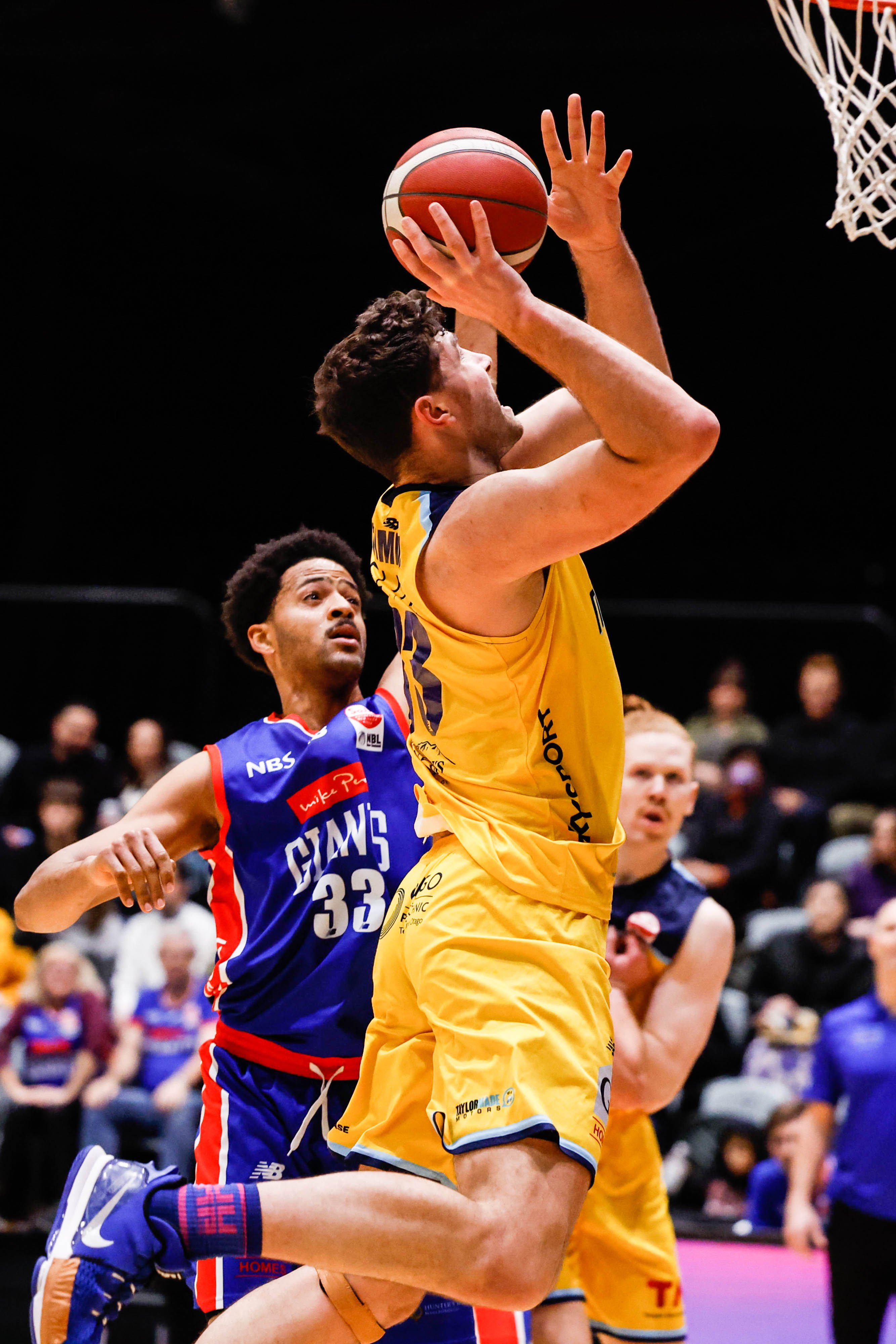 Otago Nuggets centre Sam Timmins goes to the hoop as Nelson Giants forward Trey Mourning attempts...
