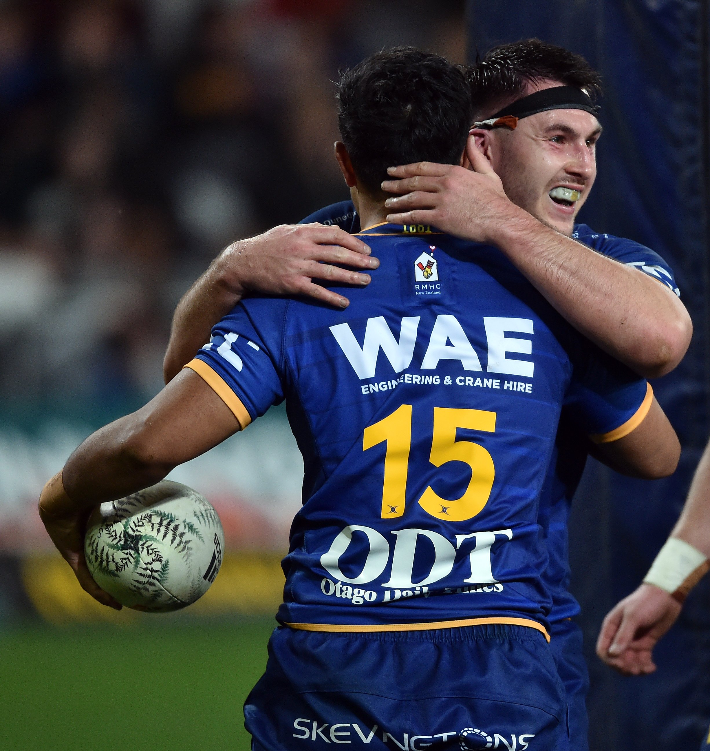 Otago fullback Josh Ioane is congratulated by hooker Ricky Jackson after scoring a try during the...