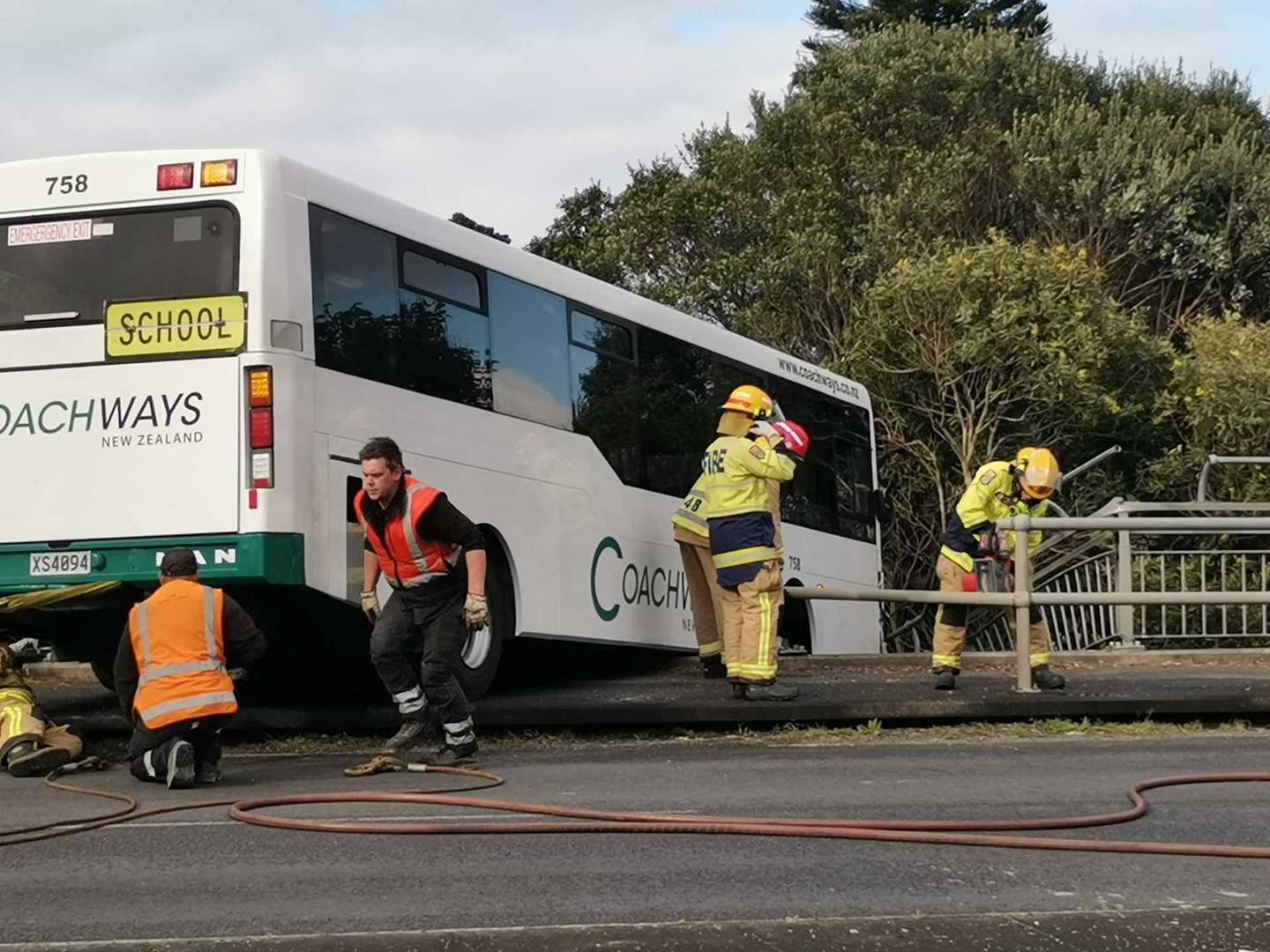 Half of the school bus is hanging over the bridge after a serious crash in central Auckland....