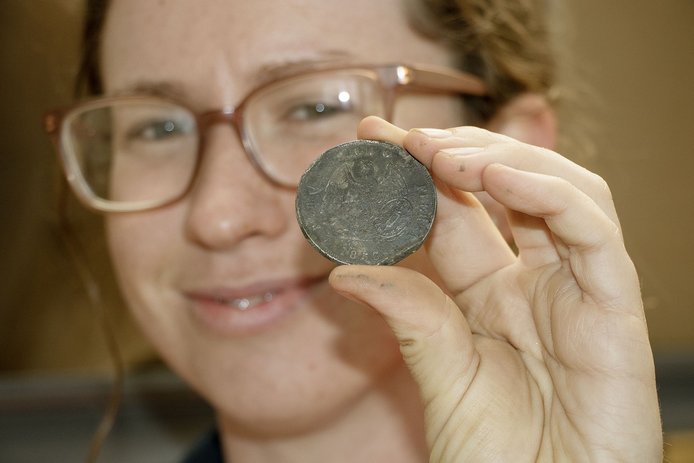 Principal archaeologist Clara Watson with a 1853 Chilean peso found at the Te Kaha dig site. She...