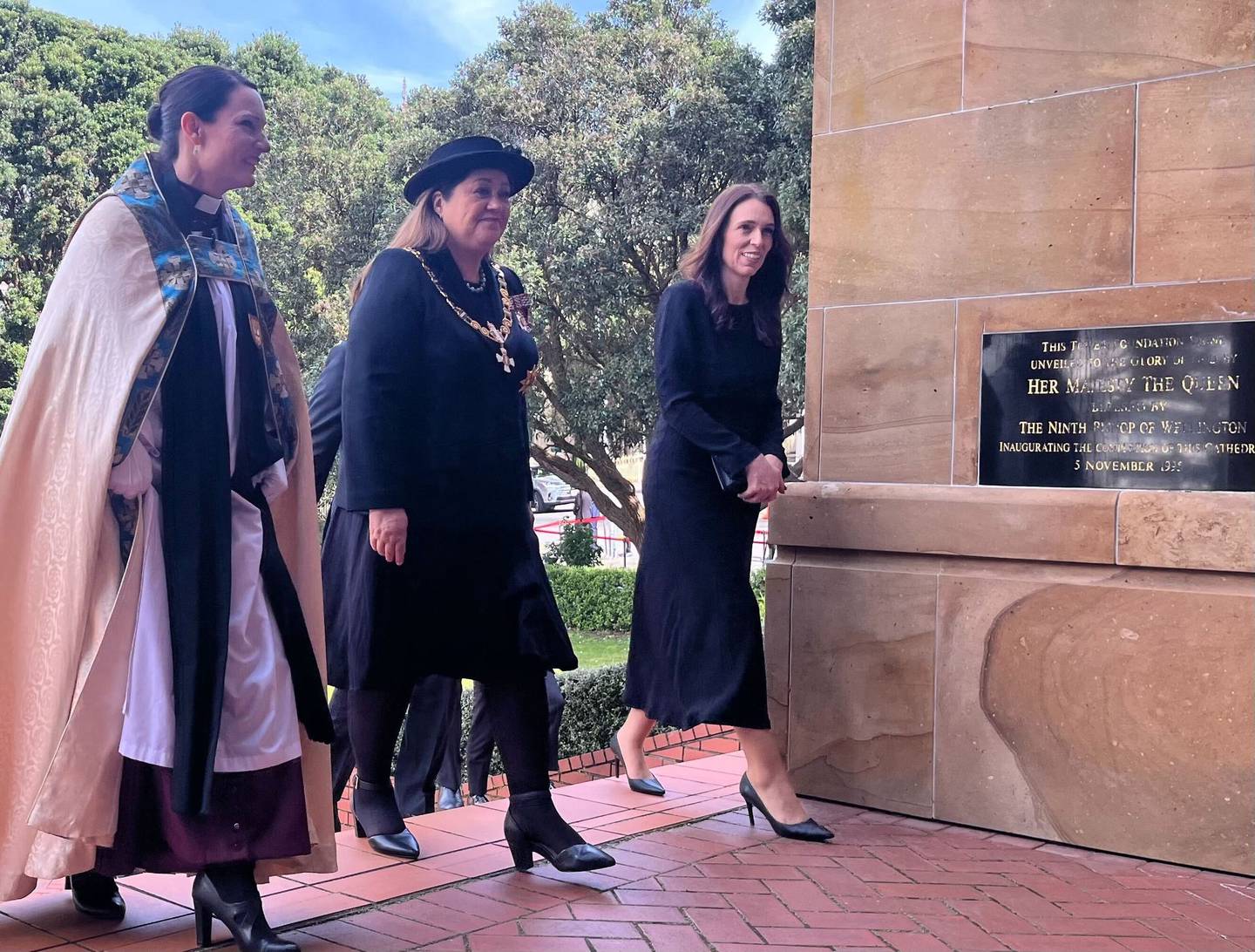 Prime Minister Jacinda Ardern (R) and Governor-General Dame Cindy Kiro (C) walking past a plaque...