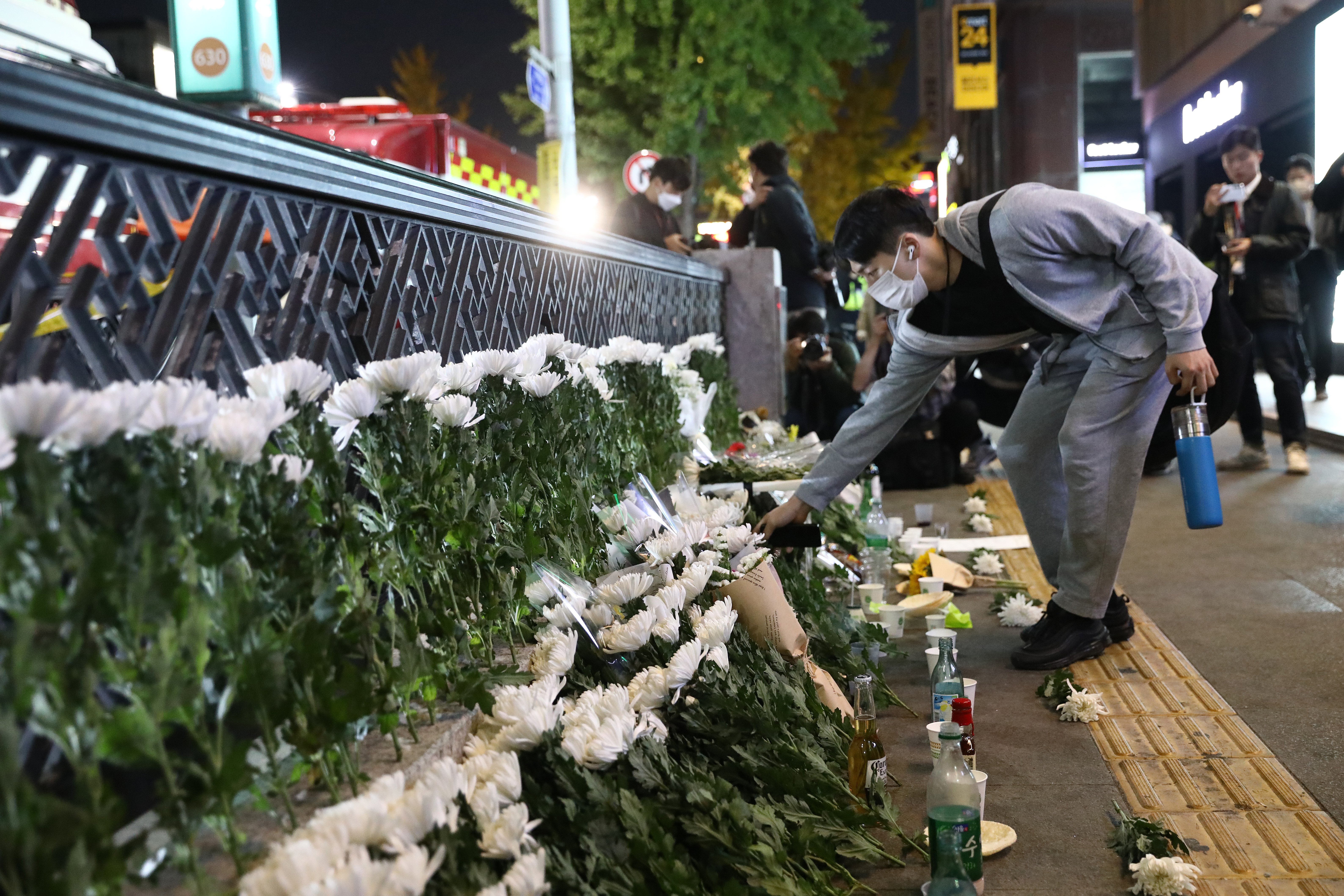 A man lays flowers as he mourns at the street of the deadly stampede during a Halloween festival...