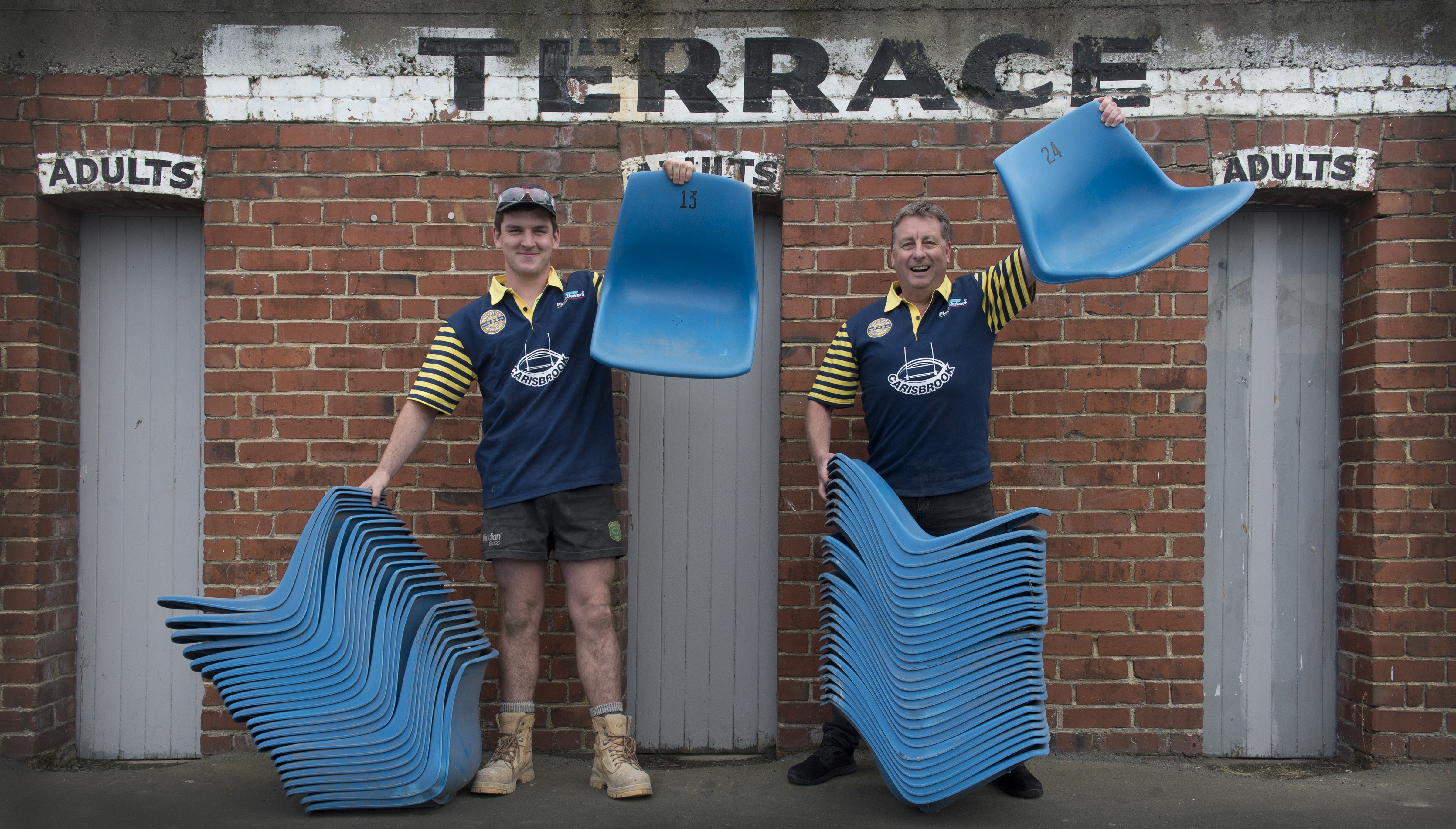 Holding up some of the former Carisbrook seats are Brent Allen Builders apprentice Andrew Rhodes ...