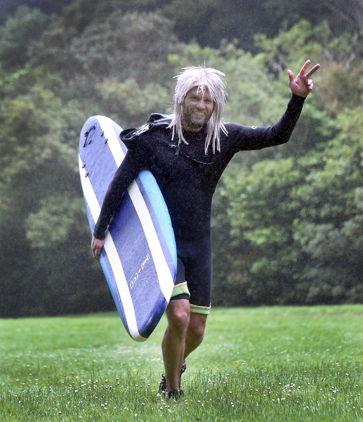Dunedin resident Pascal Saker runs in a wetsuit and carrying a surfboard during Crush the Cargill.