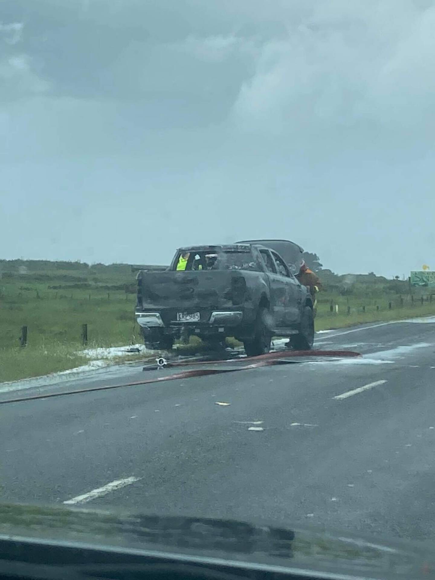 Firefighters beside the burned-out ute. Photo: Supplied