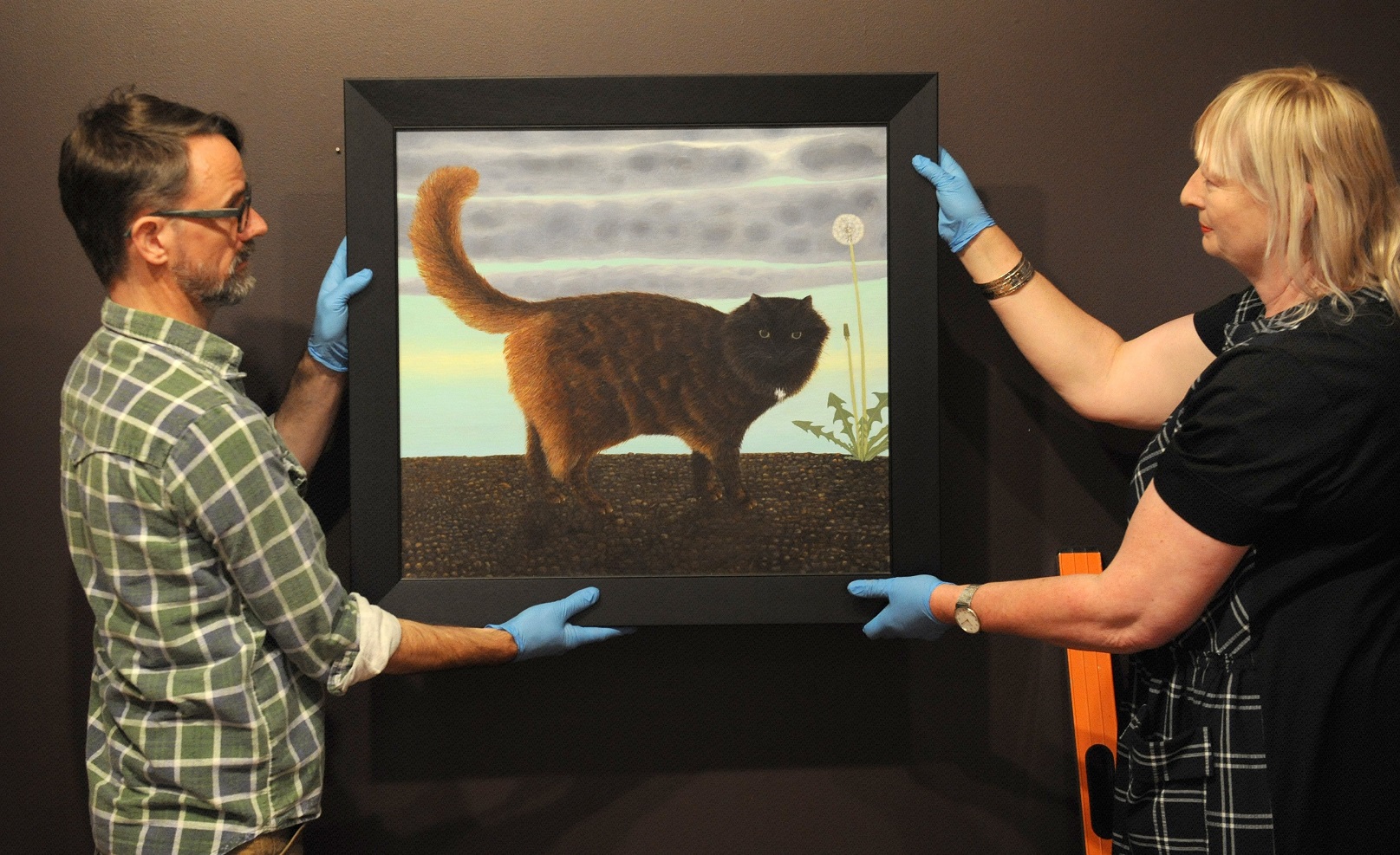 Technician Jon Chapman and head curator pictorial collection Robyn Notman hang Black Cat Walking...