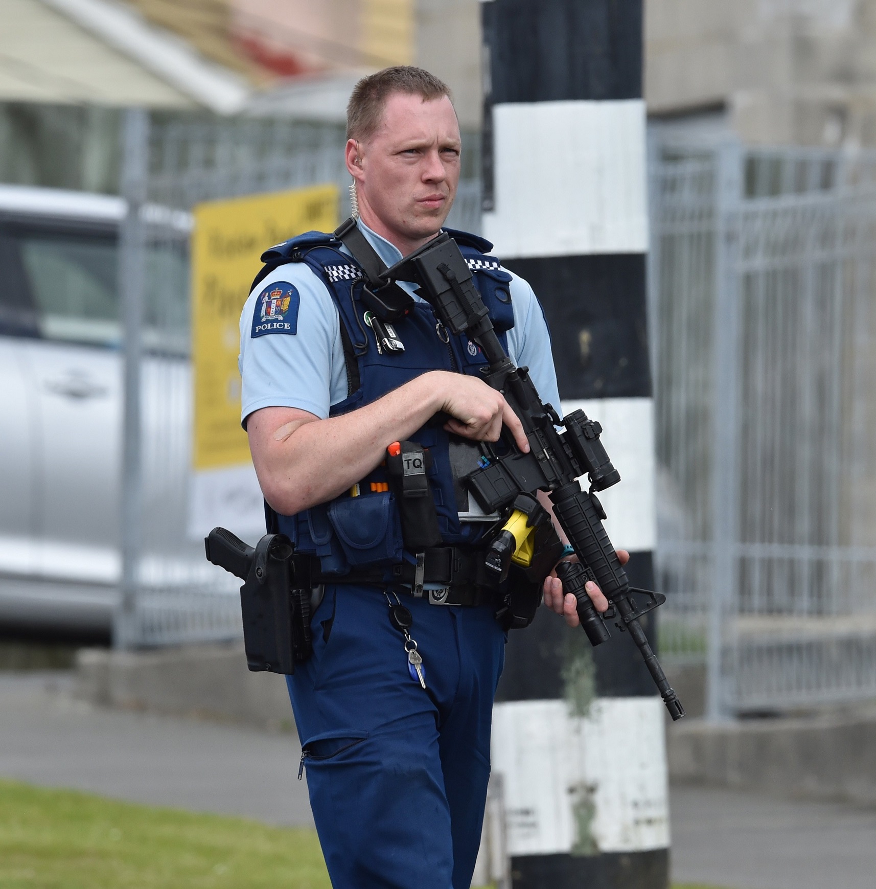 An armed police officer stands guard at a cordon at the intersection of Panmure Ave and Riselaw...