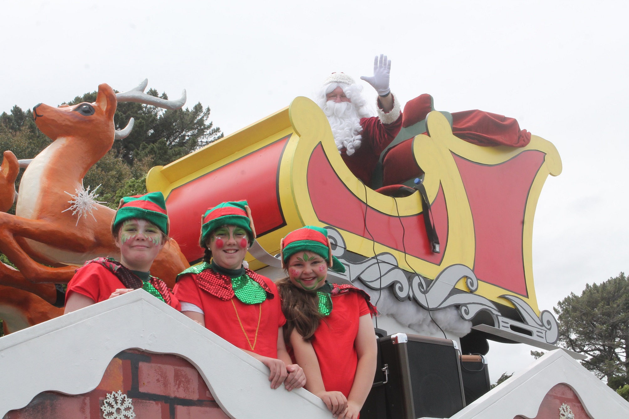 Santa Claus and his elves (from left) Meagan Saunders (11), Indee Rogers (12) and Grace Calvert ...