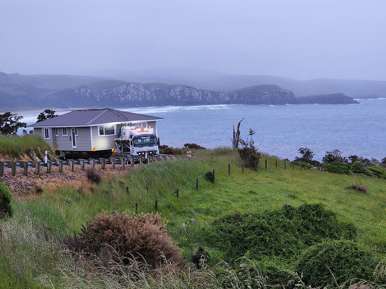 McNeilly Heavy Haulage transports a new warden’s house over Florence Hill, near Papatowai in the...