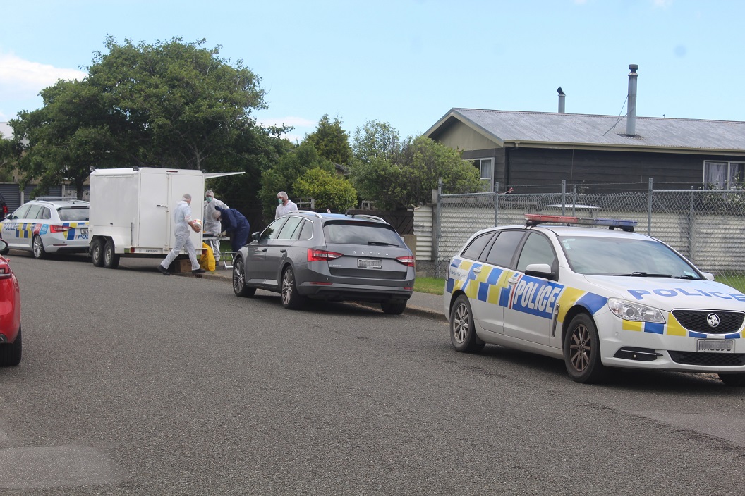 Police and forensic personnel conduct an examination of the Invercargill property following the...