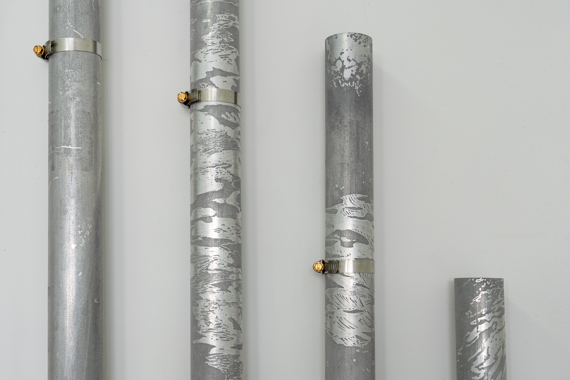 Toko toko toko toko (2021), by Madison Kelly. Etched aluminium, hose clamps, sticks, mallets,...