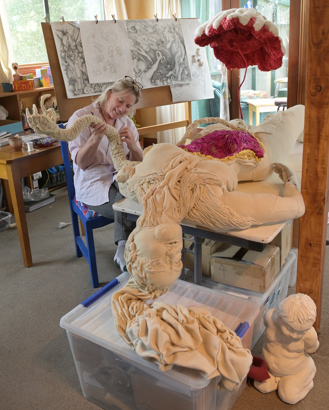Artist Lissie Brown works on her Eve sculpture at her home in Brighton. Her breast ‘‘flower’’ and...