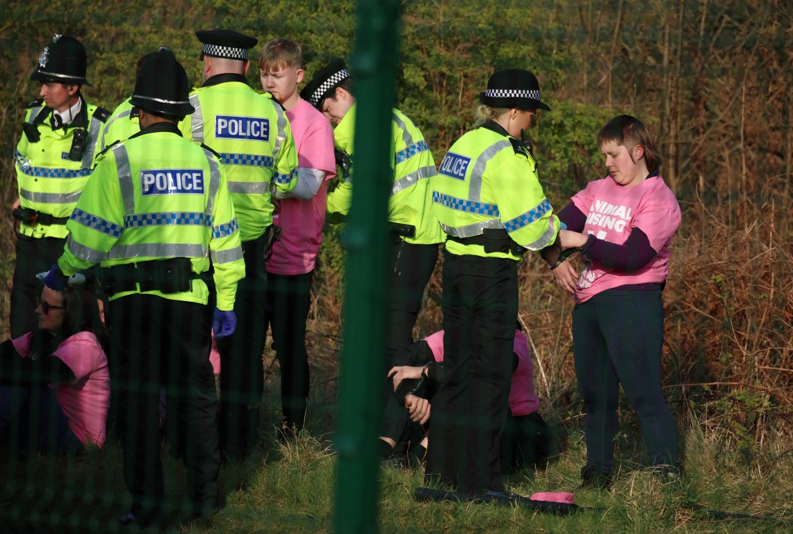 Detained animal rights activists with police officers at Aintree Racecourse. Photo: Reuters