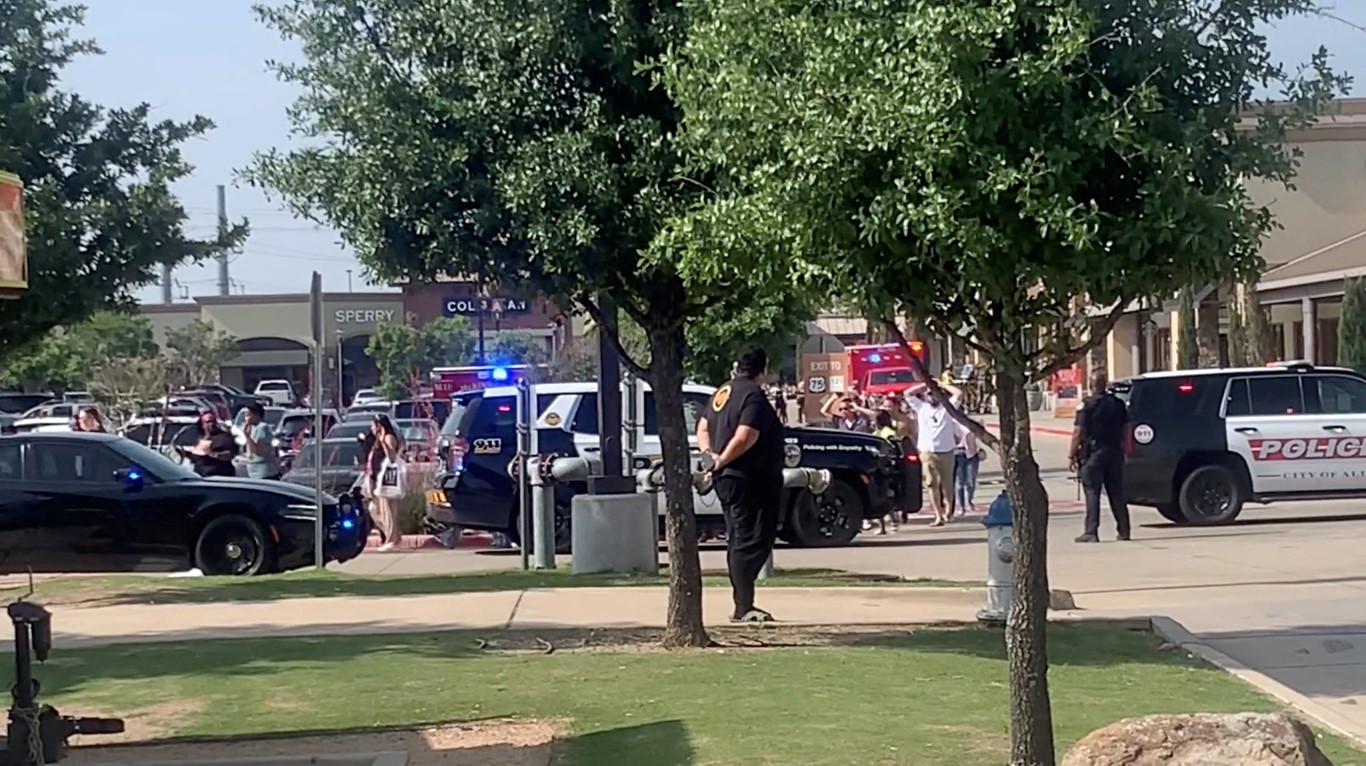 People exit Allen Premium Mall as emergency services attend the scene after the shooting in Allen...