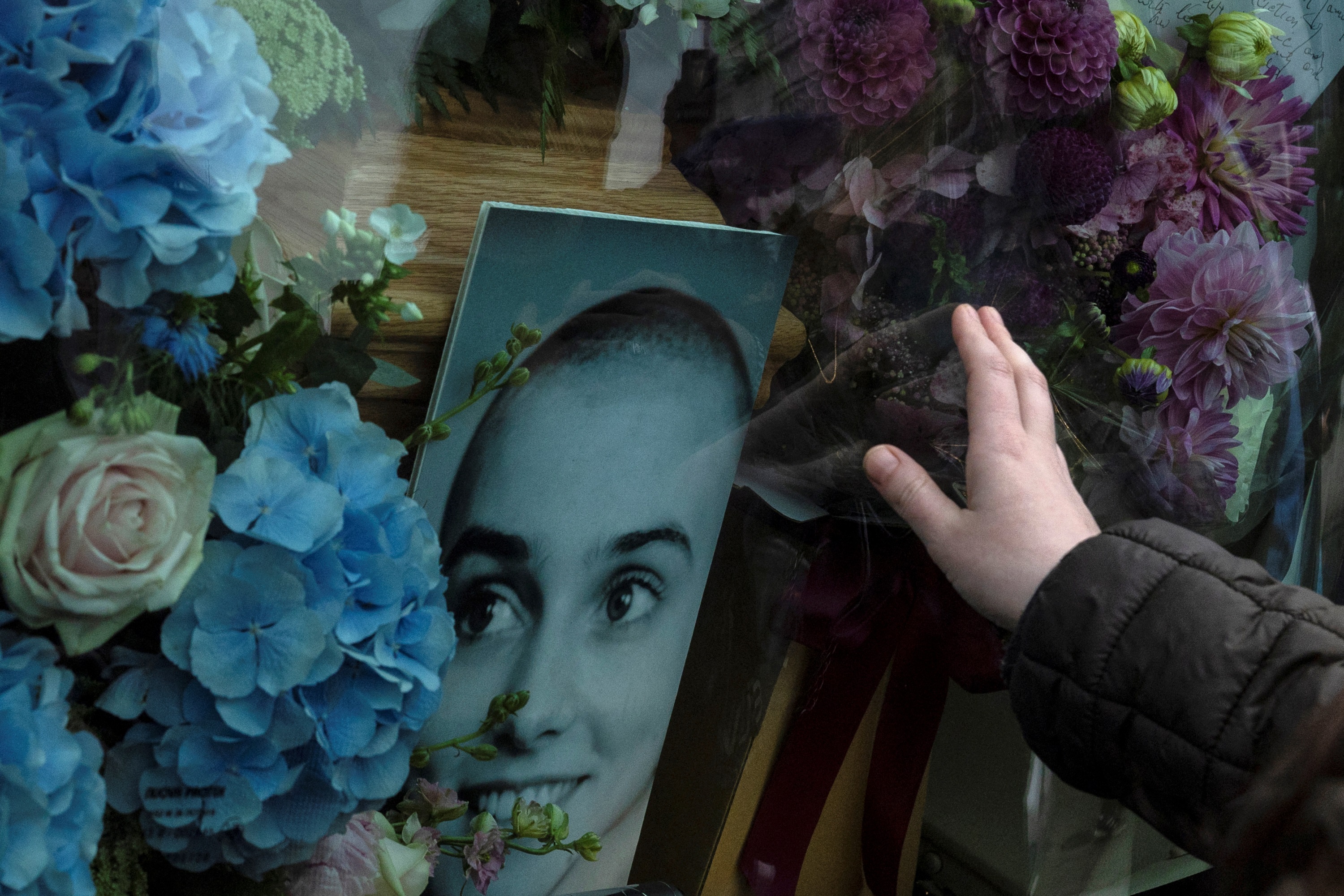 A woman touches the hearse of Sinead O'Connor, who died on July 26 in London. Photo: Reuters