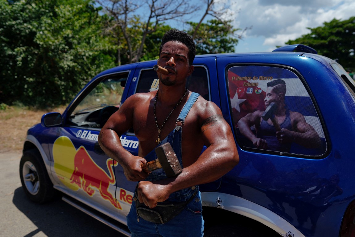 Cuba's "Ironman" Lino Tomasen poses beside his car before performing to beachgoers in Guanabo....