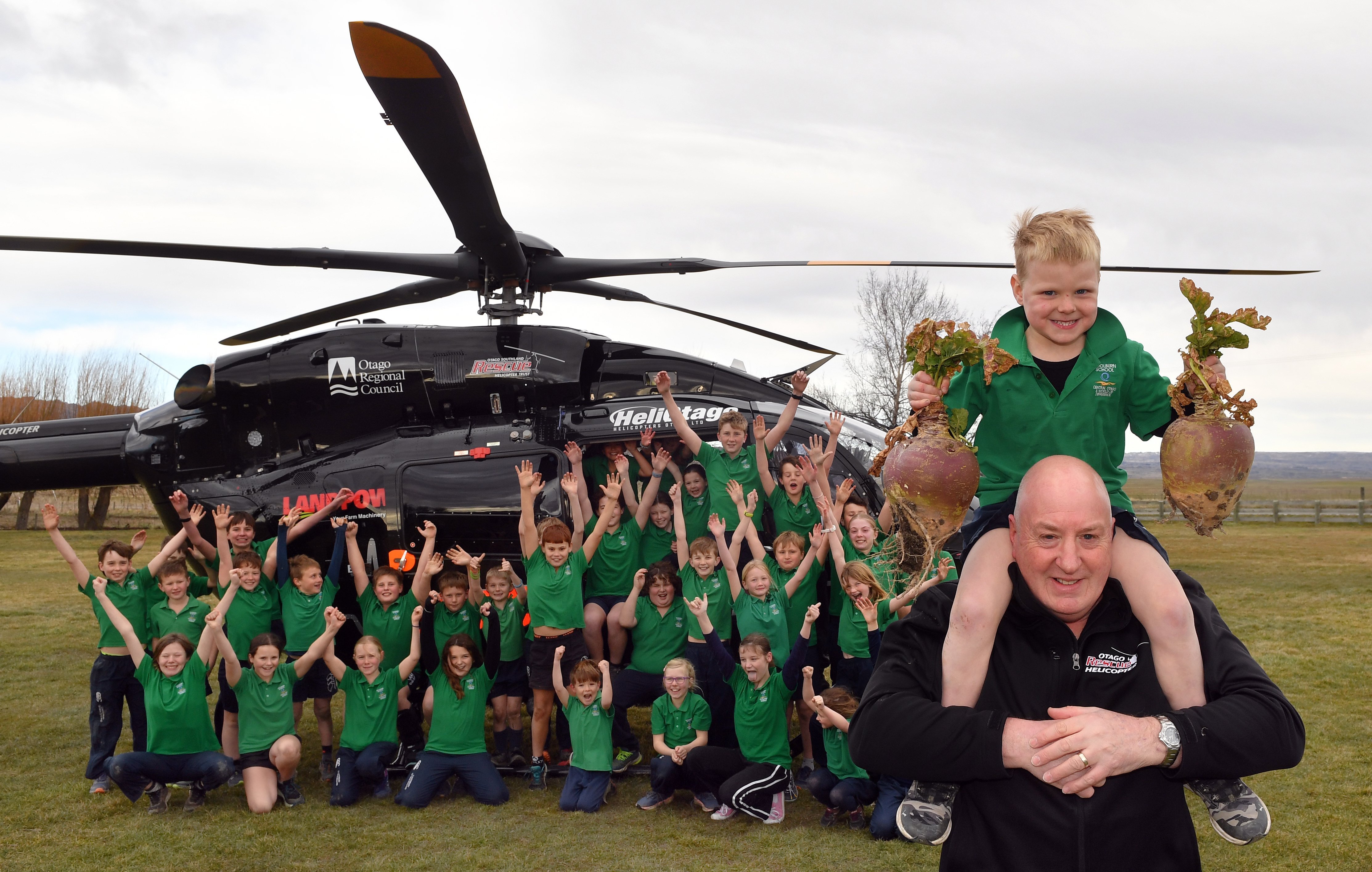 Perching on paramedic team leader Shayne Henry’s shoulders is Fletcher Rutherford, 6, proudly...