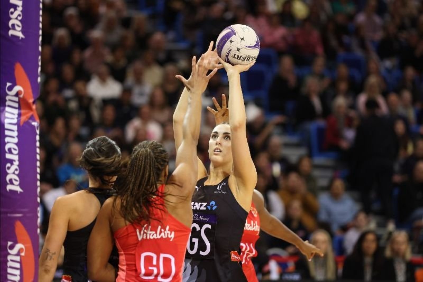 Silver Ferns goal shoot Amelia Walmsley prepares to shoot for goal while being guarded by England...