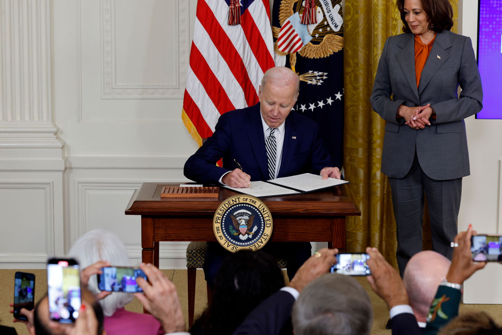 US Vice President Kamala Harris watches President Joe Biden sign a new executive order at the...