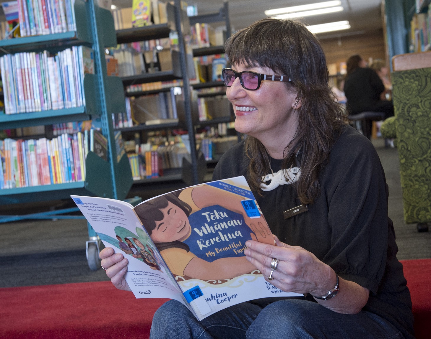 Dunedin Public Library youth services supervisor Lynn Vare with one of the books from bilingual...