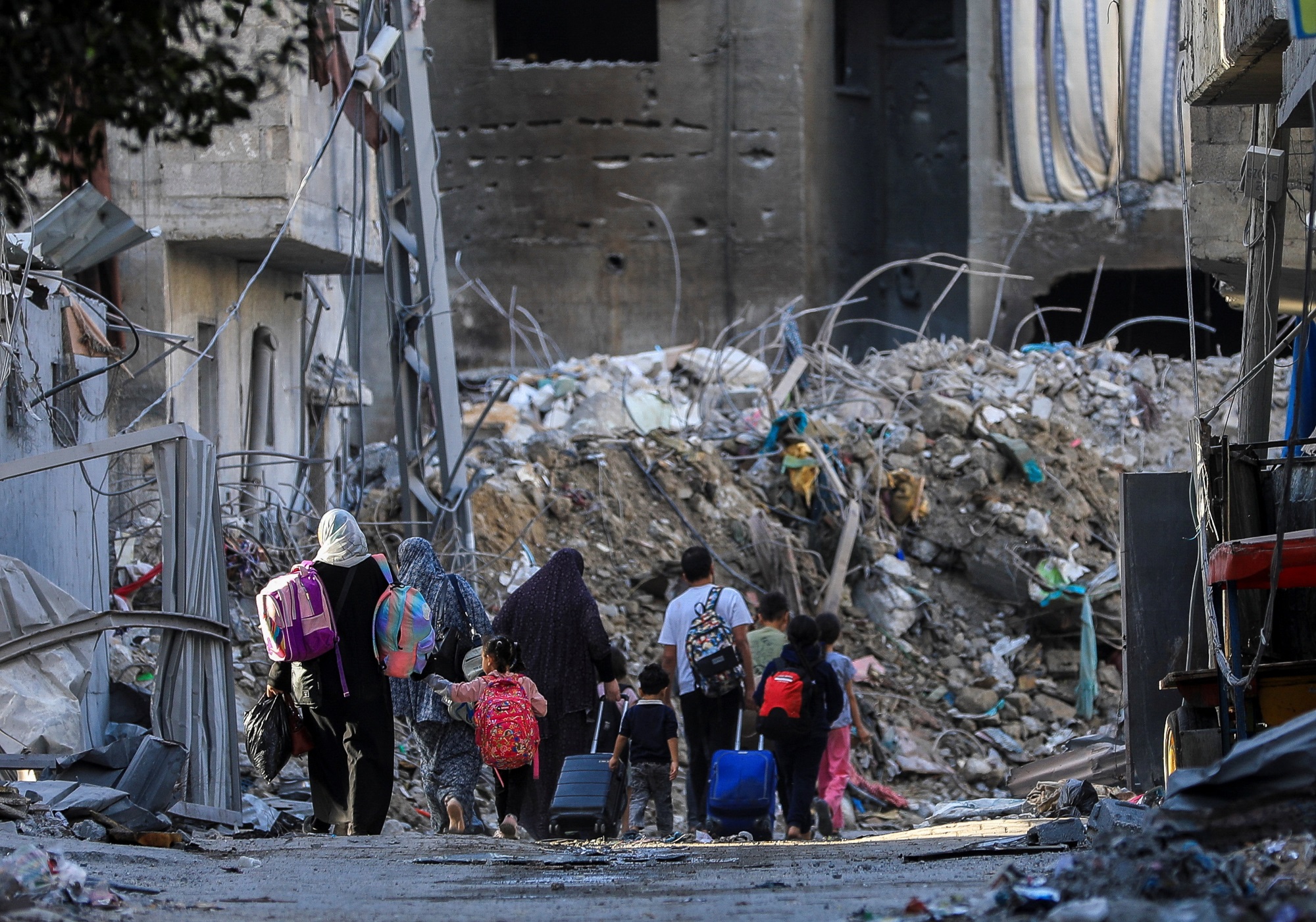 Palestinians carry their belongings as they flee destroyed homes in Gaza City. Photo: Reuters 