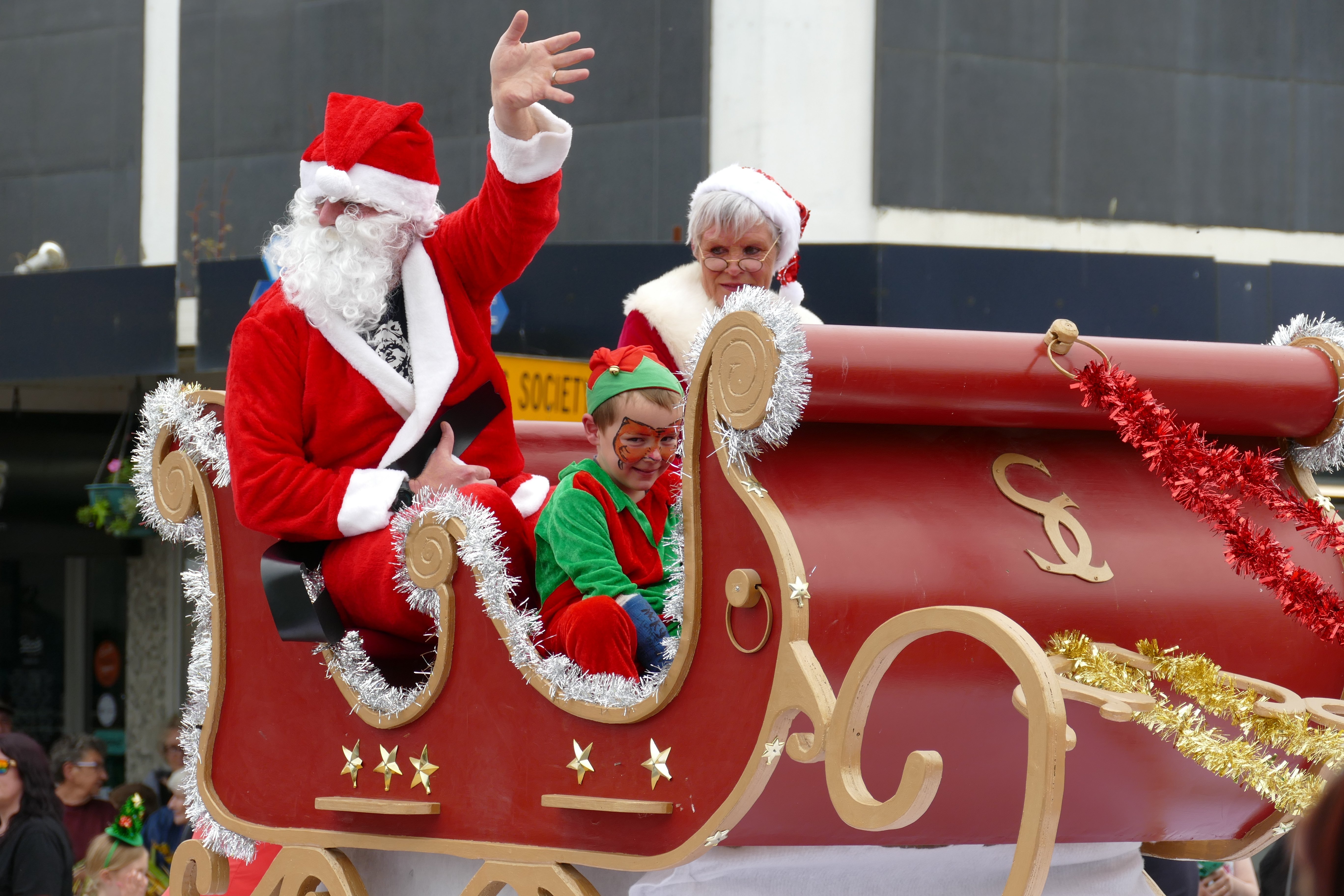 Santa, Mrs Claus and a mischievous elf greet crowds from Santa's sleigh at the Clutha Country...