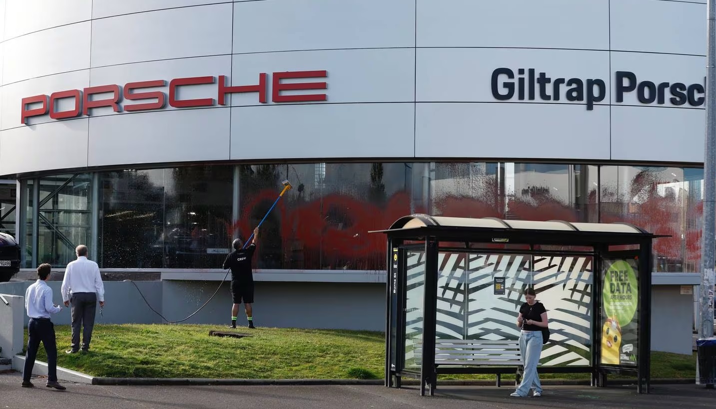 Cleaning up at an Auckland car yard that was targeted in the attack. Photo: NZ Herald
