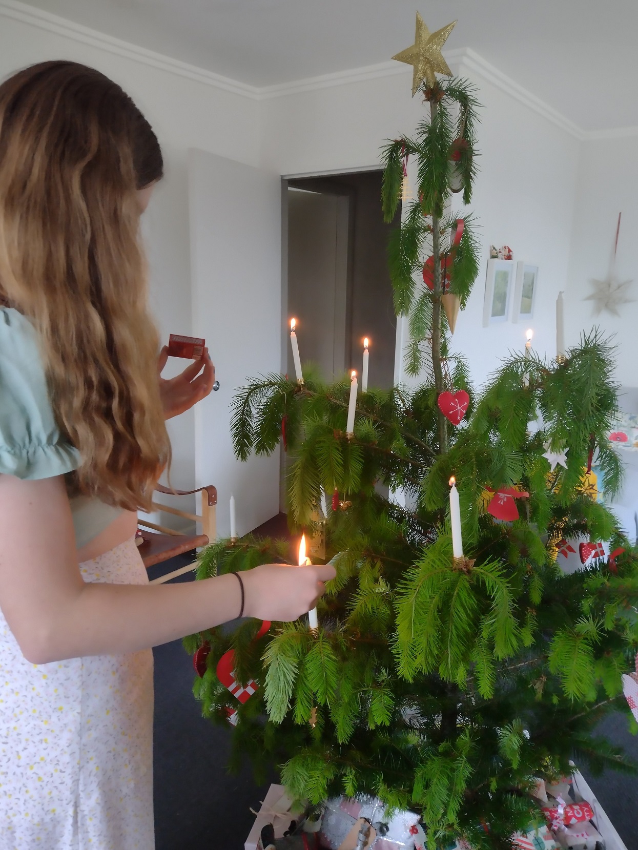 Anna Goodin lights a candle on the family’s Christmas tree. Danish families decorate a tree with...