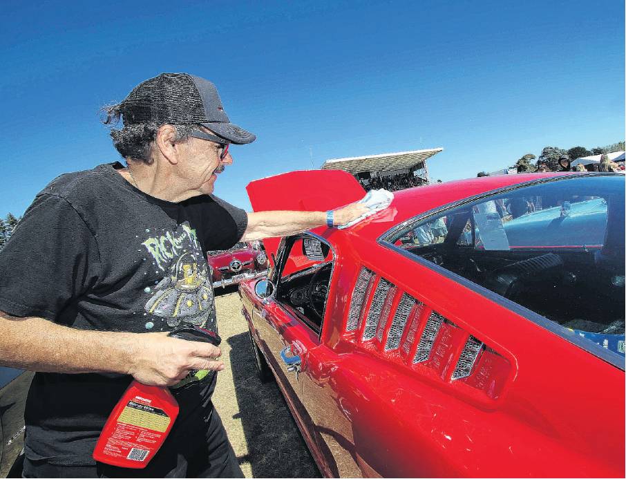 Richard Tremblay cleans some dust off the Ford Mustang Fastback car he restored and sold to a...