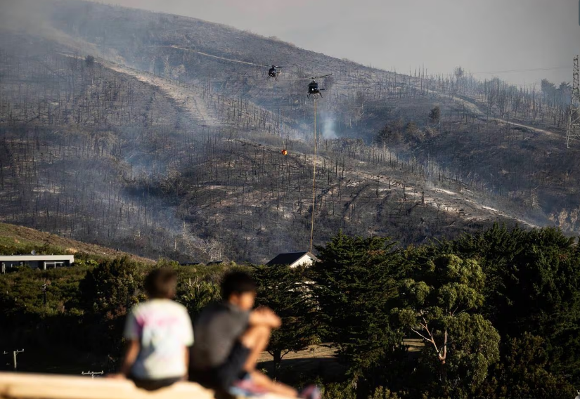 Helicopters resumed work to try and control the Port Hills fire early this morning. Photo: NZ...