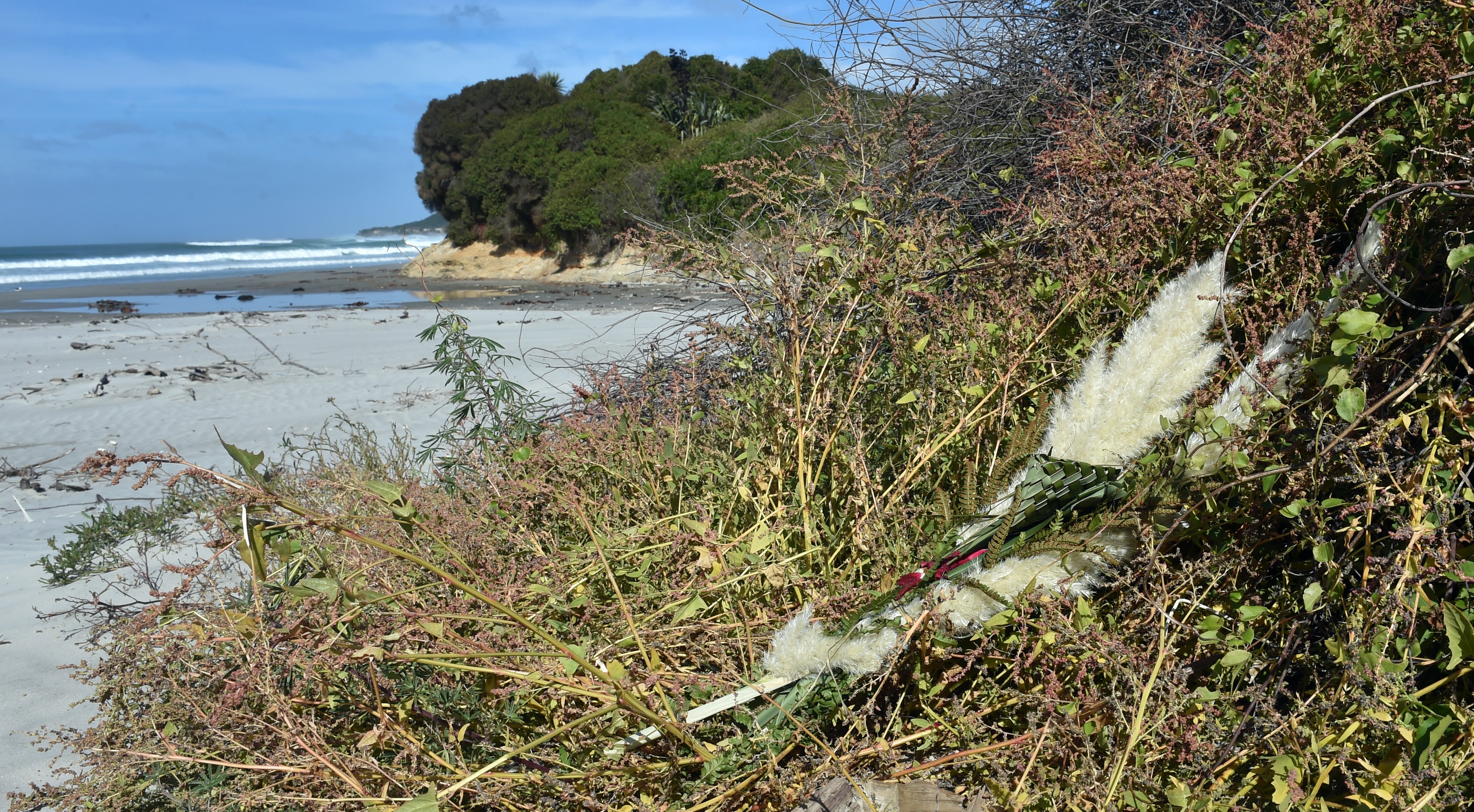 A wreath lies amid the vines at Taieri Mouth yesterday as the community mourns a young girl...