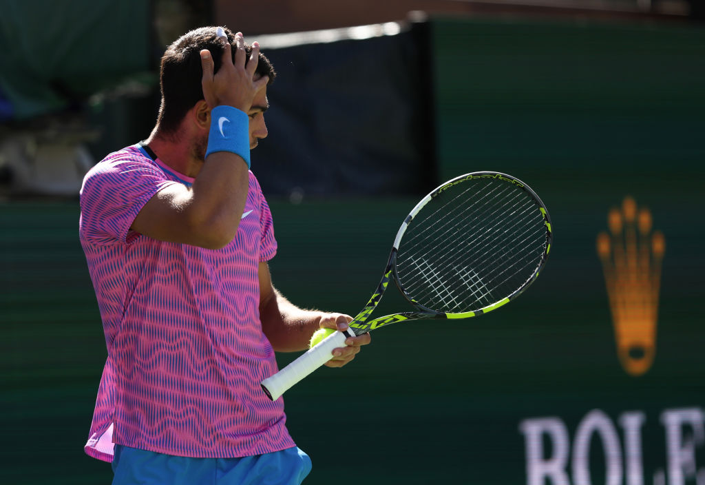 Carlos Alcaraz tries to swat away bees that interrupted his match at Indian Wells. Photo: Getty...