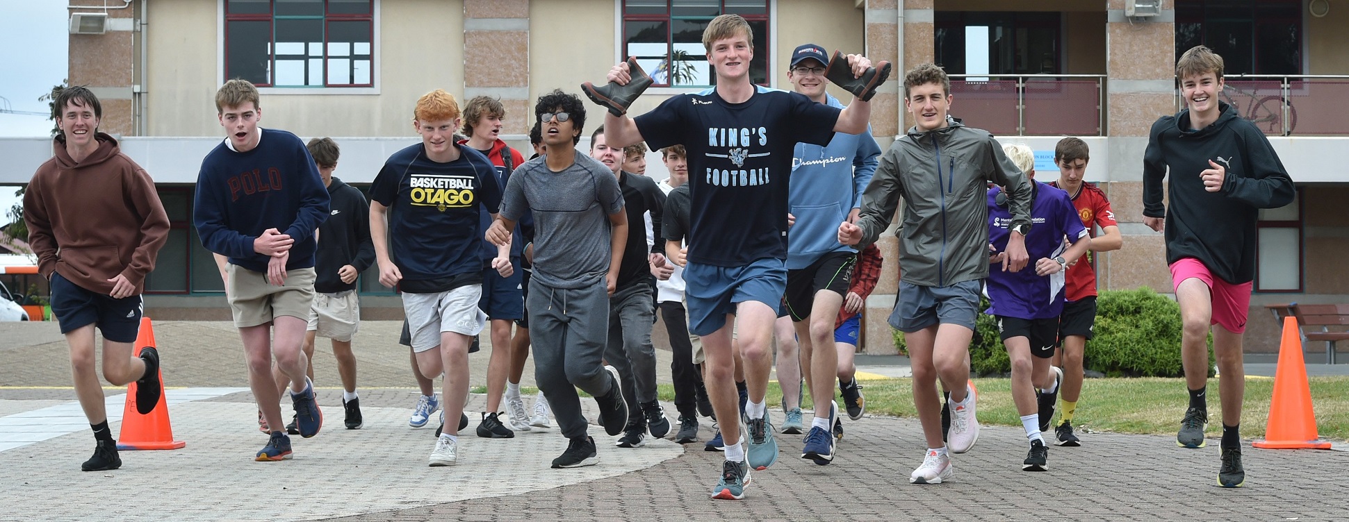 King’s High school pupil Josh Scott, 17, holds a pair of gumboots as he leads his peers as they...