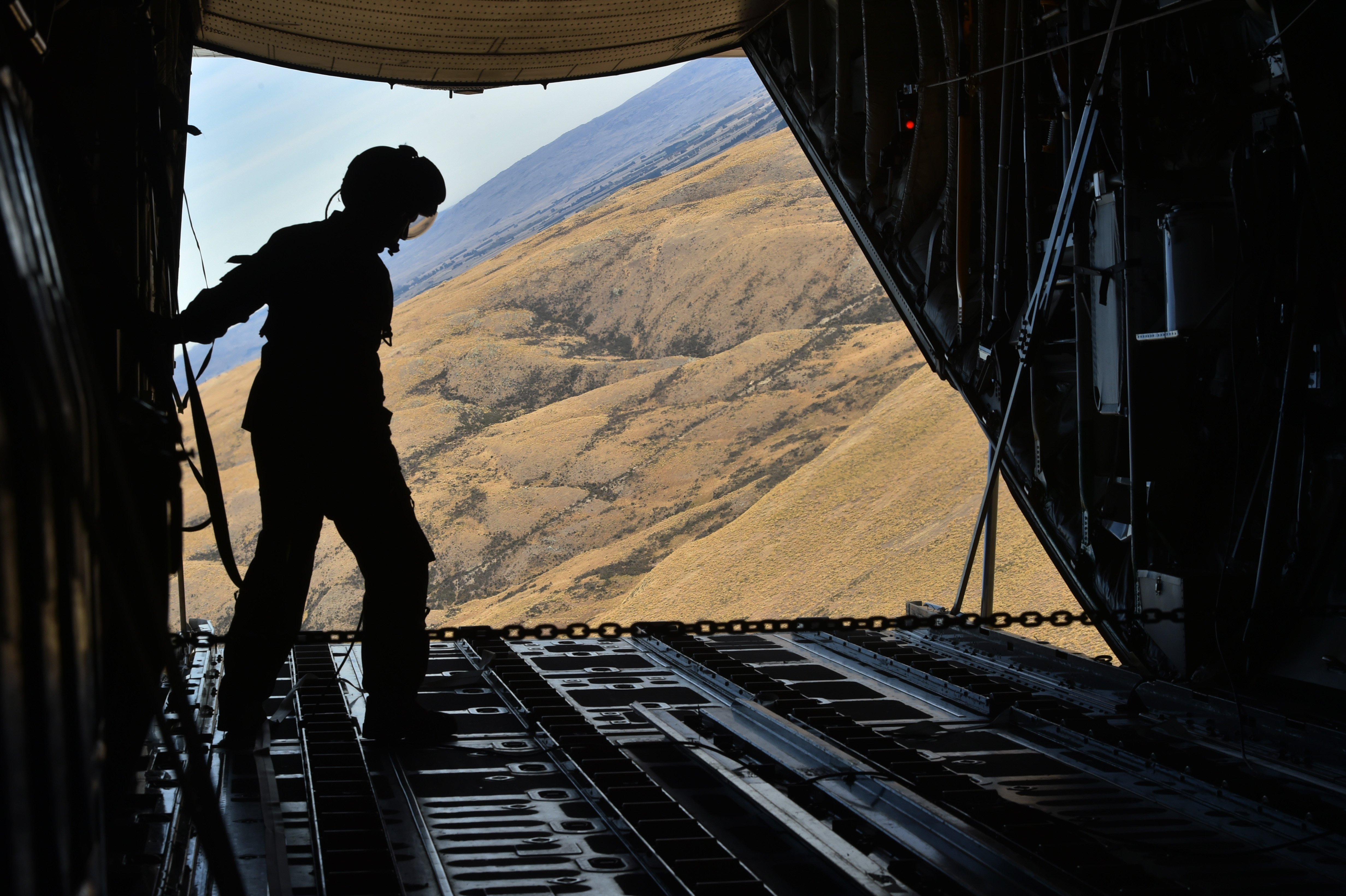 A loadmaster steadies himself on a Royal New Zealand Air Force Lockheed C-130H Hercules, after a...