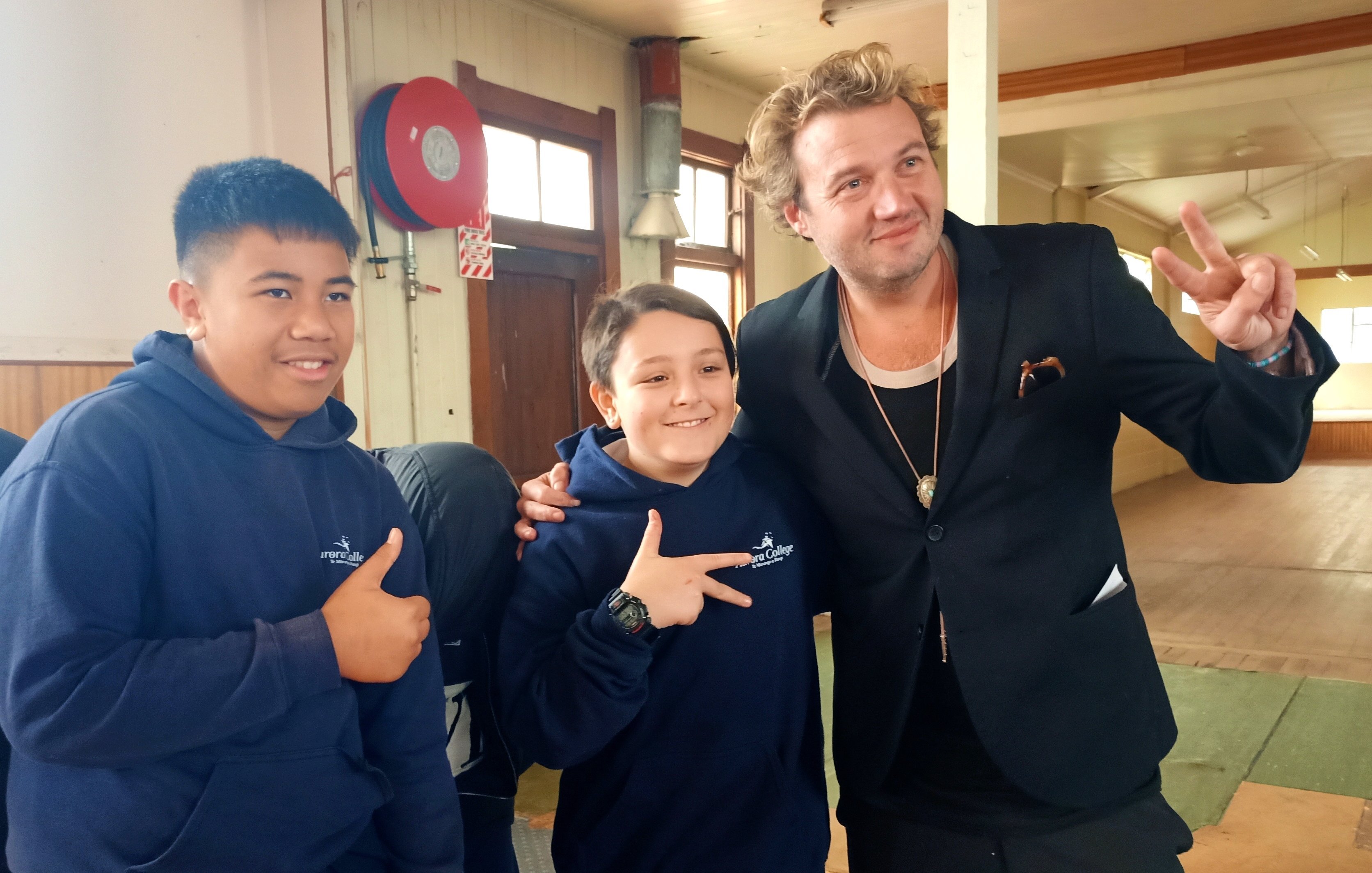 Six60 bassist Chris Mac takes a moment yesterday with Aurora College pupils Joepira Arake (left)...