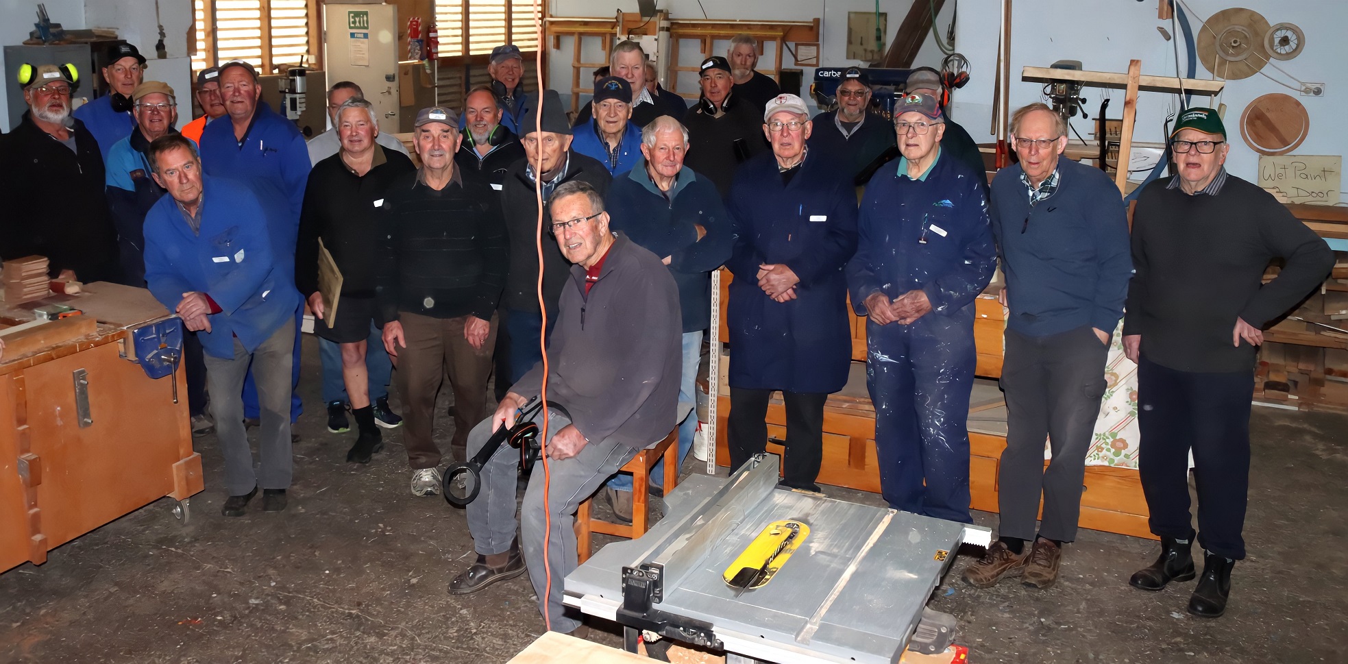 Taieri Blokes Shed members gather at their workshop by the Taieri Airfield.