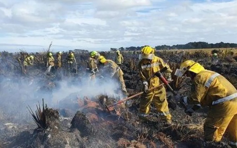 Firefighters work on the smouldering peat wetlands at Awarua Bay in April 2022. Photo via RNZ