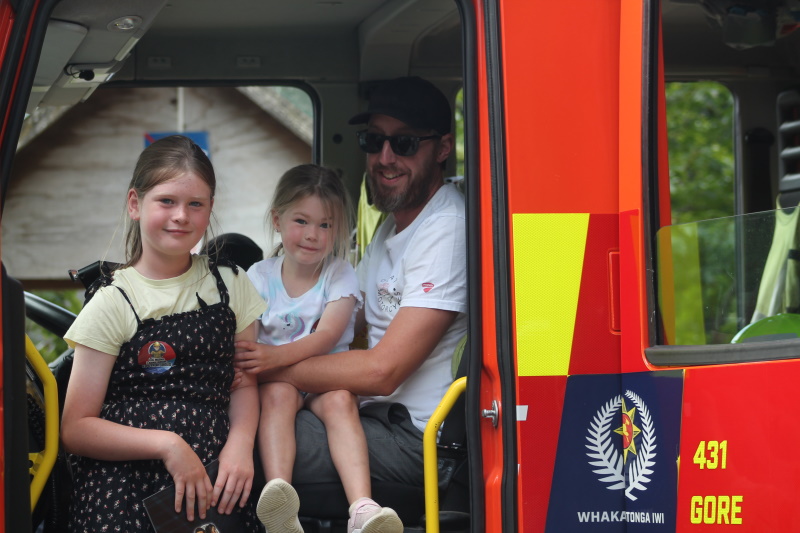 Macie, 9, and Evie Mikkelson, 4, check out the interior of a fire engine with their uncle Mal...