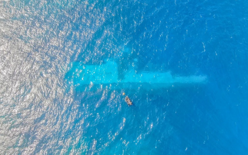 New Zealand Navy divers survey the area around HMNZS Manawanui on the southern coast of Upulo....