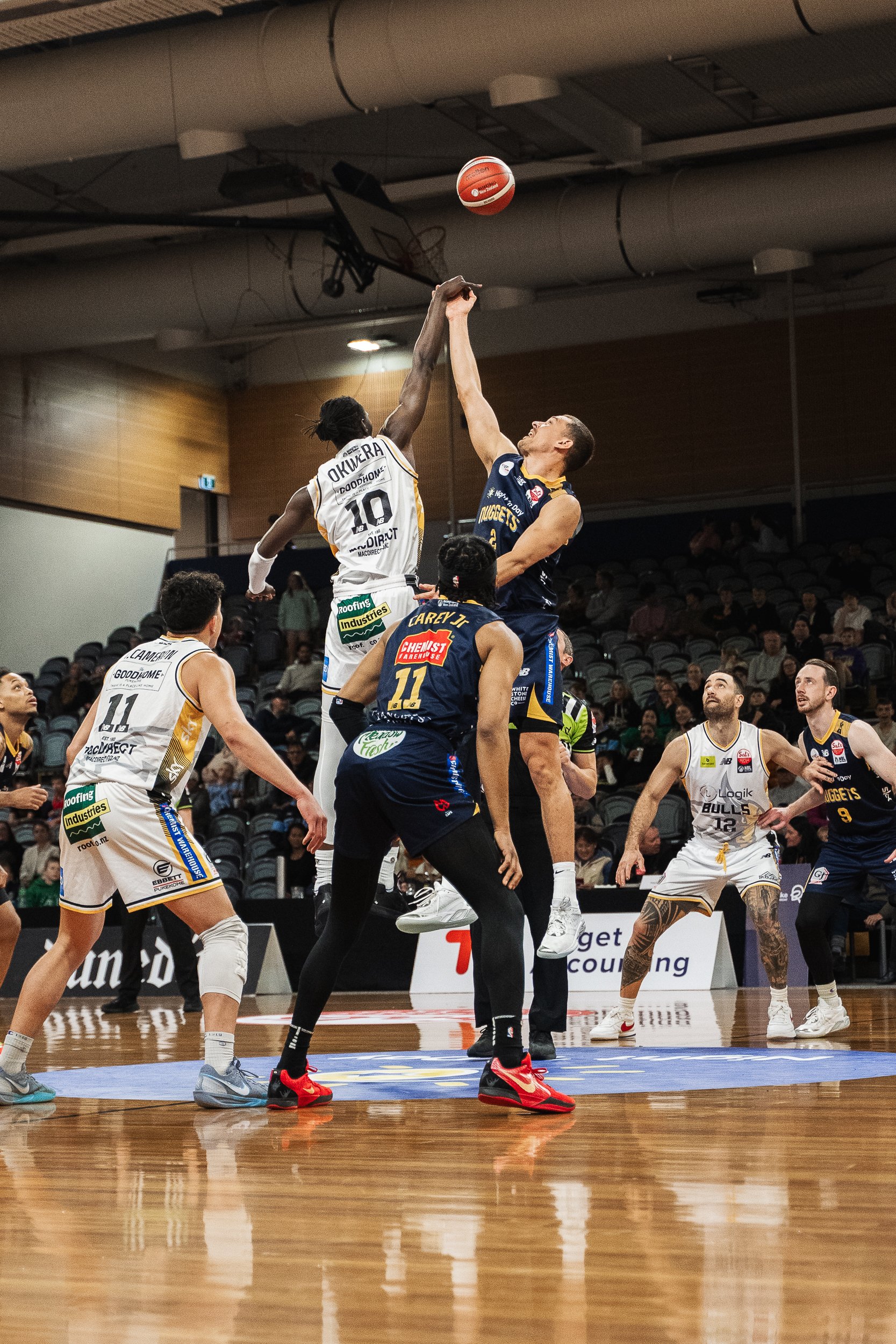 Otago Nuggets forward Jonathan Janssen (left) and Franklin Bulls forward David Okwera compete for...